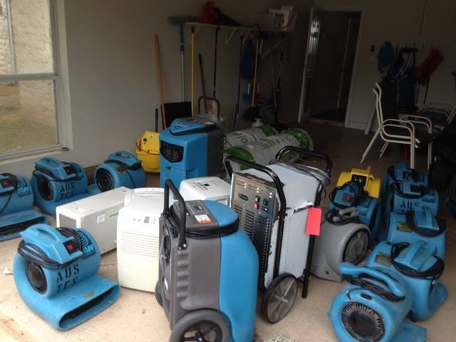 Dehumidifiers and air movers staged in a Largo, FL garage for a structural drying job