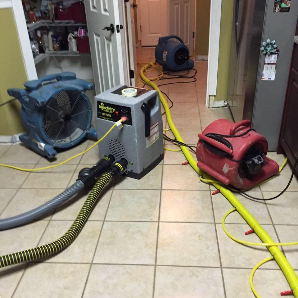 Injection drying system and air movers on a tile floor after a water leak in Largo, FL
